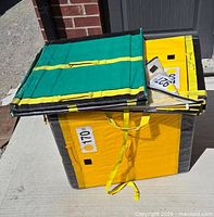 Three yellow and black zippered packing boxes, one lid open showing green interior panel