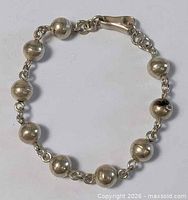 Full view of bracelet showing eight beads and clasp