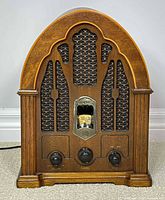 Front view showing arched wood cabinet, speaker grille, dial, and control knobs