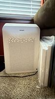 Front view of Winix air purifier next to sealed filters