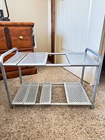 Front view of silver metal two-tier perforated rack