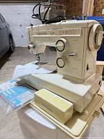 Kenmore sewing machine with foot pedal, manual, accessories visible