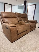 Front angle of brown manual reclining loveseat showing both seats, center console, pull handle