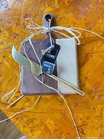 Cutting board and cheese knife tied with raffia, tags visible