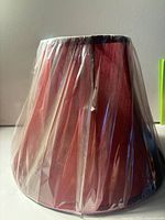 Front view of red empire lampshade wrapped in plastic