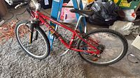 Full left-side view of red Specialized Stumpjumper mountain bike on floor