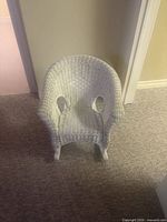 Front view of white wicker child chair showing overall design and condition