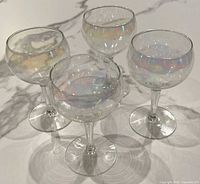 Four iridescent coupe champagne glasses grouped together