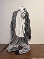 Full view of gray and white husky kigurumi onesie hanging