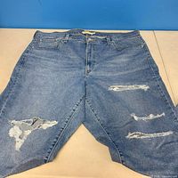 Front view of Levi Strauss & Co distressed jeans showing ripped areas and overall style