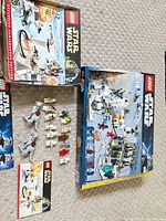 Overview of both set boxes, loose minifigures, two Tauntauns and instruction booklets on carpet