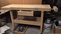 Full view of hardwood workbench showing vise, dog holes, center drawer, lower shelf and tray