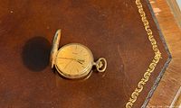Closed hunter pocket watch on leather surface