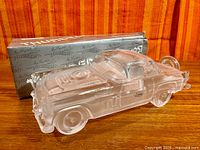 Side view of clear crystal Thunderbird sculpture with box in background
