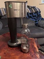 Front view of SodaStream machine with bottle beside it