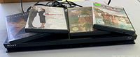 Sony Blu-ray player with four DVD cases resting on top