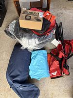 Pile view showing boxed Pankay shower, bagged shelter, folded chair, air mattress and other gear