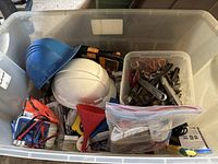 Overview of bin contents including helmets, multimeter, tools and funnel