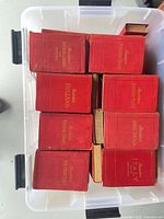 Top view of plastic bin containing multiple red Baedeker guides