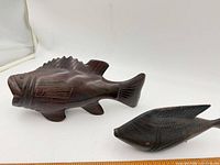 Both carved wooden fish sculptures side by side