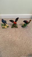 Front view of three Lenox bird figurines on carpet