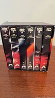 Front view of six VHS tapes in slipcase showing titles on spines
