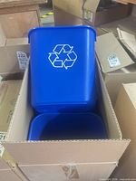 Blue plastic bin with white recycling symbol nested in carton