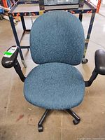 Front view showing blue fabric upholstery, arms, base