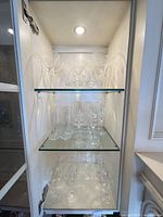 Entire cabinet view showing mixed clear stemware and beer glasses