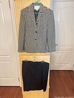 Blazer on hanger above matching skirt