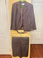 Full view of jacket, skirt and belt displayed