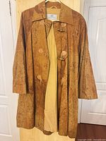 Full view of coat front hanging, showing overall style, length and lining