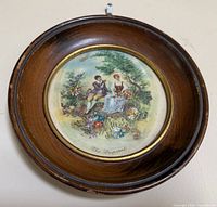 Front view of round framed needlepoint artwork