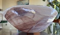 Side profile of pink swirled glass bowl showing shape and coloration