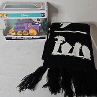 Boxed Funko Pop! Disney 07 Jack Skellington in purple train engine next to folded black white scarf