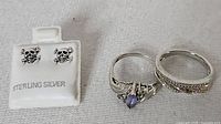 Skull stud earrings on card, two sterling rings beside