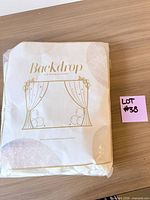 Front of packaged white/ivory polyester backdrop curtain