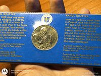 Obverse side of medallion showing Pope John Paul II portrait within blue bilingual display card