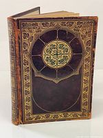 Front cover showing leather binding with gilt grapevine border and medallion