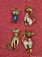 All four cat brooches laid out on cloth