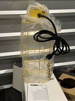Light removed from box showing yellow cage, power cord, instruction sheet