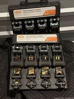 Two HDX 4-packs of camo ratchet tie-downs opened in carrier cases