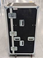 Front view of the black Olympic flight case showing latches, handles and casters