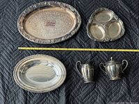 Group shot showing all five silver-plated items with measuring tape