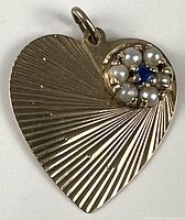 Front view showing sunburst design, pearl cluster, blue stone