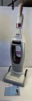 Full view of Electrolux Versatility EL8501 upright vacuum cleaner standing upright with manual in foreground