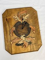 Full view of wooden wall clock showing fish motif and clock hands