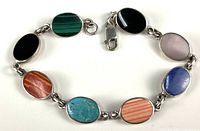 Full view of sterling silver bracelet showing eight multi-color cabochons and clasp