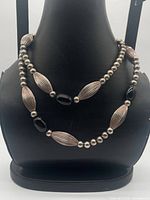 Full necklace displayed on bust showing bead pattern and length