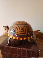 Left side view of hand-painted wooden turtle on stand